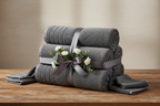 6-piece dark grey towel set as a gift on a wooden table