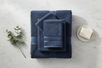 Navy blue Turkish cotton towels folded on marble countertop
