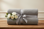 Pale grey Turkish cotton towels as a gift on a wooden table