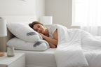 Woman sleeping on white pinch-pleat hotel pillows